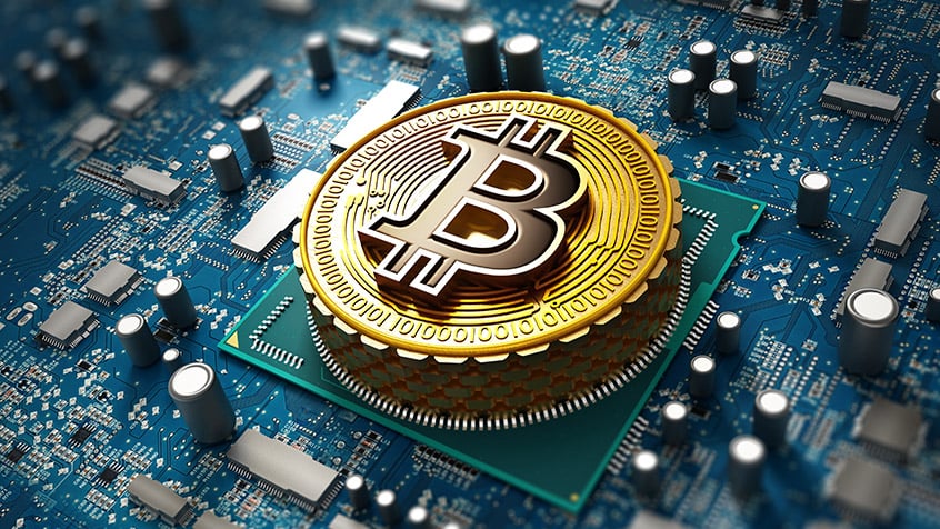 Bitcoin laid on top of a circuit board.